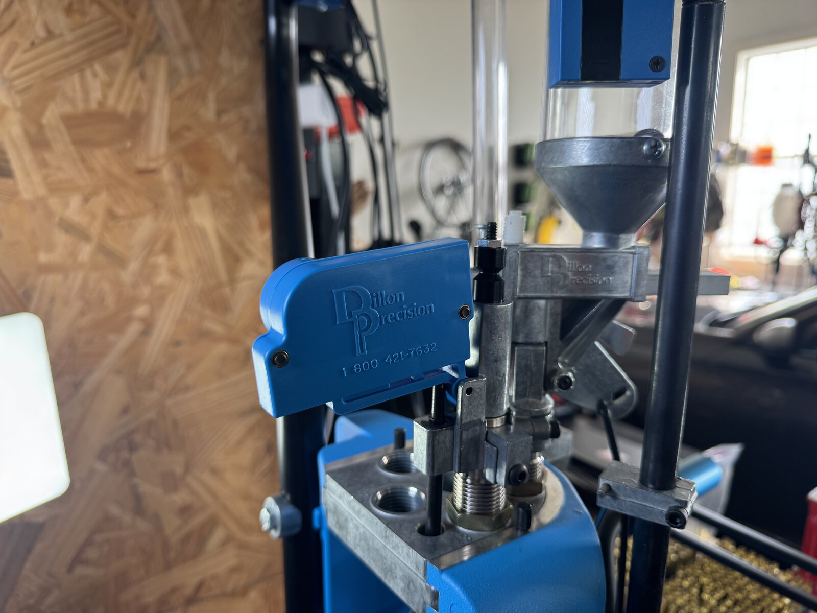 Close view of a progressive press toolhead with several threaded stations and a powder measure installed