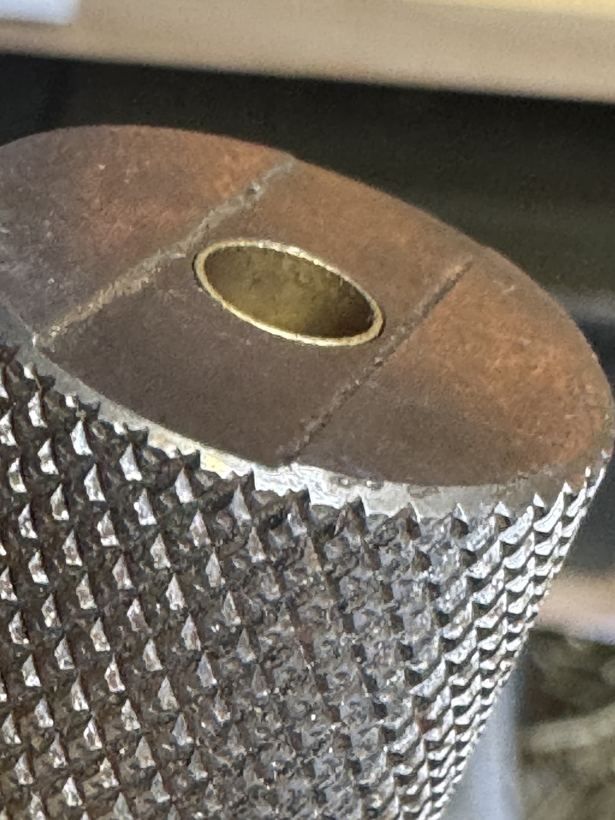 A 5.56 case held in a knurled metal headspace gauge during the commissioning inspection